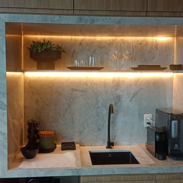 Detalhe de nicho em mármore branco com iluminação embutida